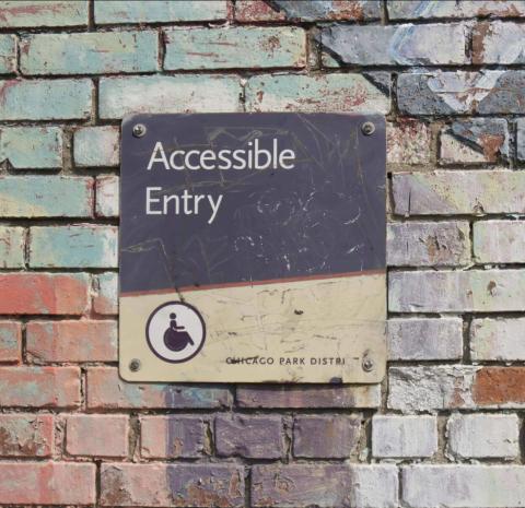 Murad vägg med skylt &quot;accessible entry&quot;