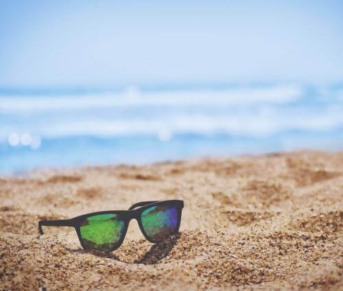 Solglasögon på sandstrand